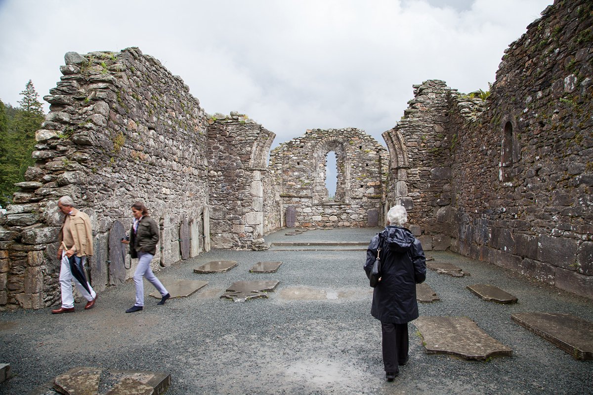 Visitors explore old church ruins at Glendalough