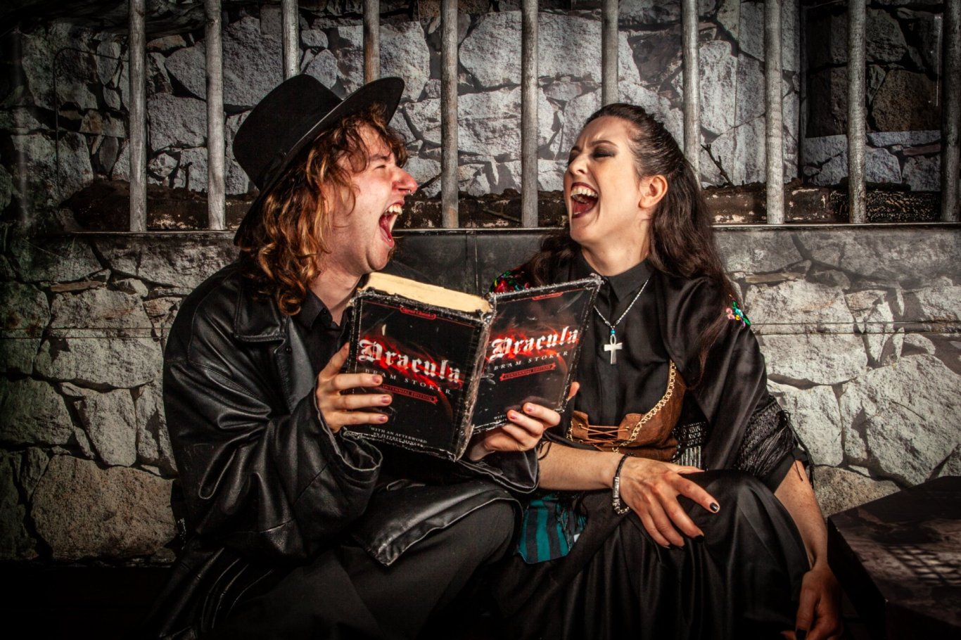 man and woman laughing while holding dracula book